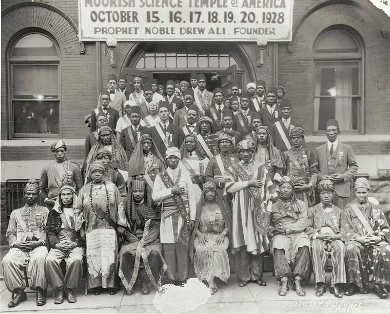 123 Prince Street
Members of the Moorish Science Temple of America posing before meeting place during annual gathering, October 1928; Prophet Noble Drew Ali Founder [first row, standing, fifth from left.
Moorish Science Temple of America photograph collection. 
